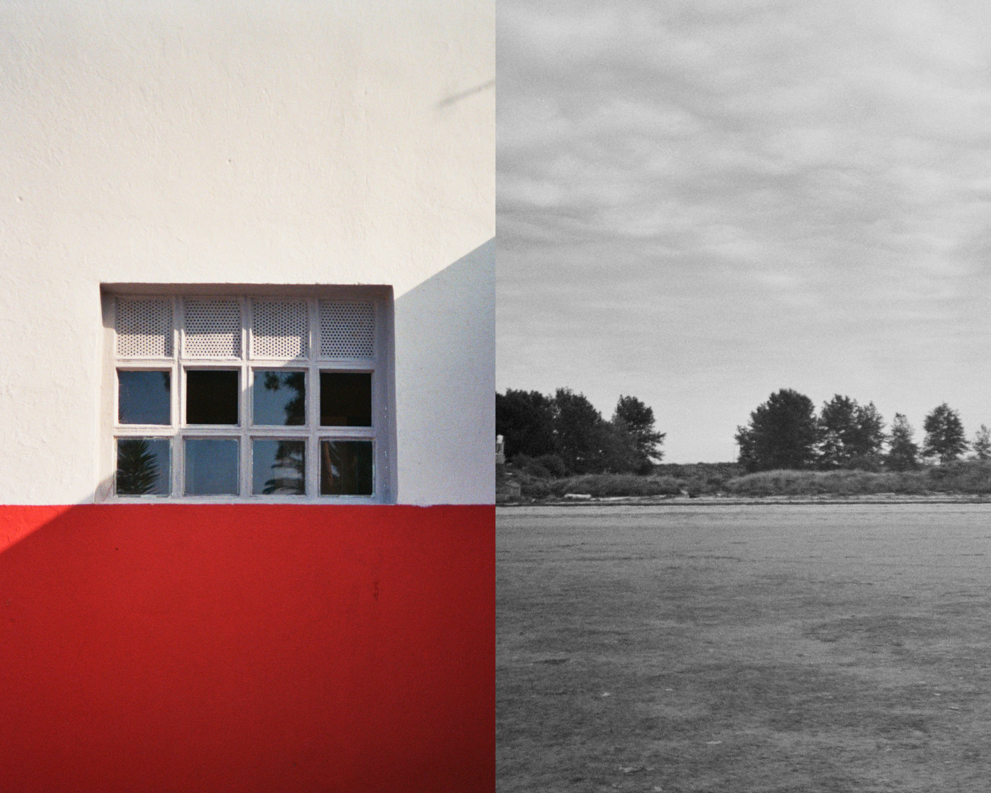 Ventana sobre pared roja y blanca junto a un campo