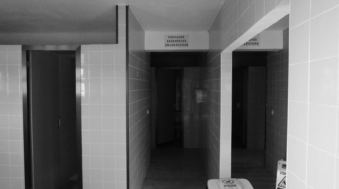 Vestuario con el cartel «Por favor sean breves en las duchas»