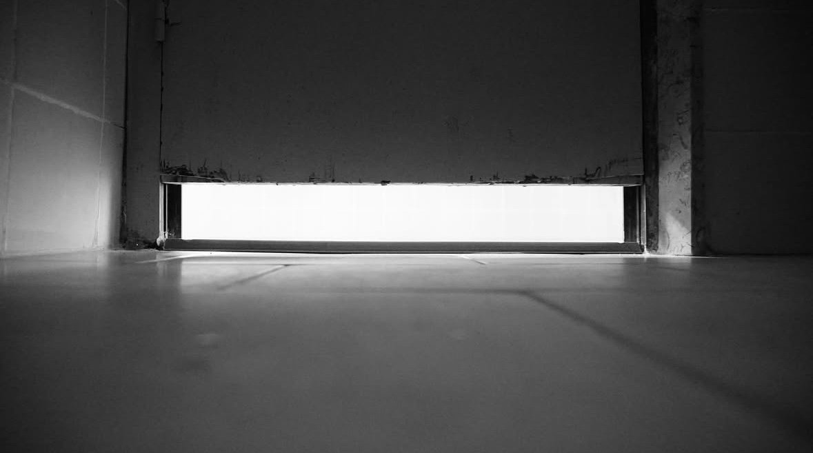 Luz bajo la puerta de una ducha, a ras de suelo