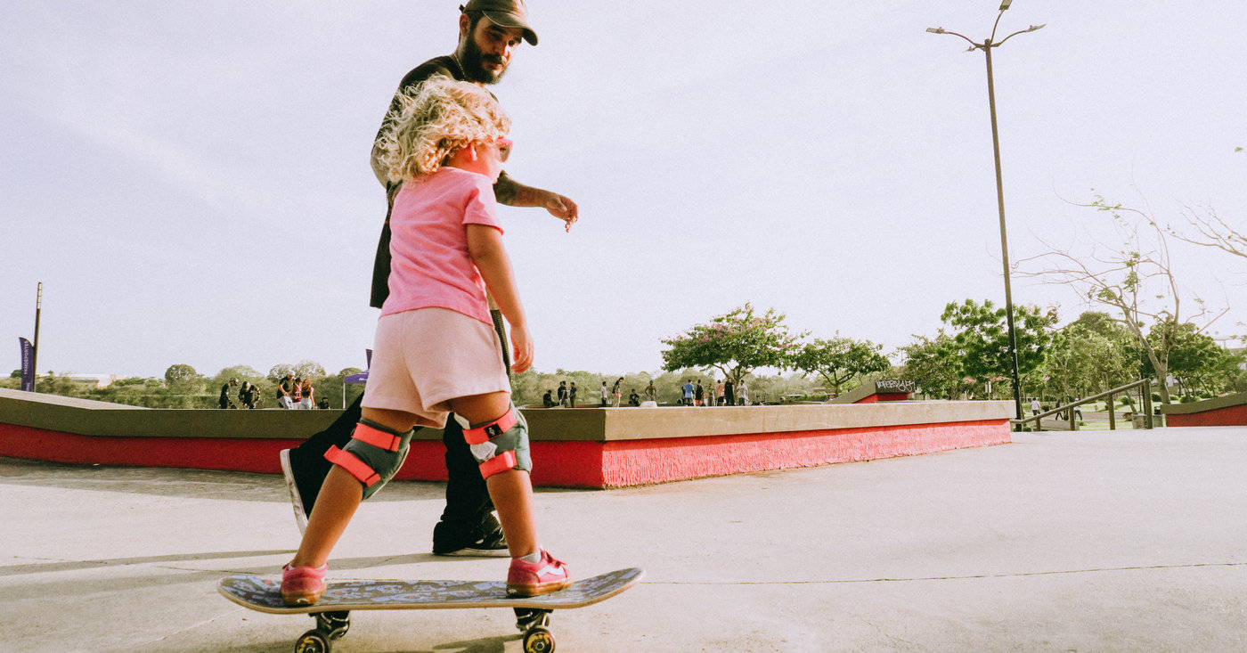 Niña aprendiendo a patinar en un skatepark